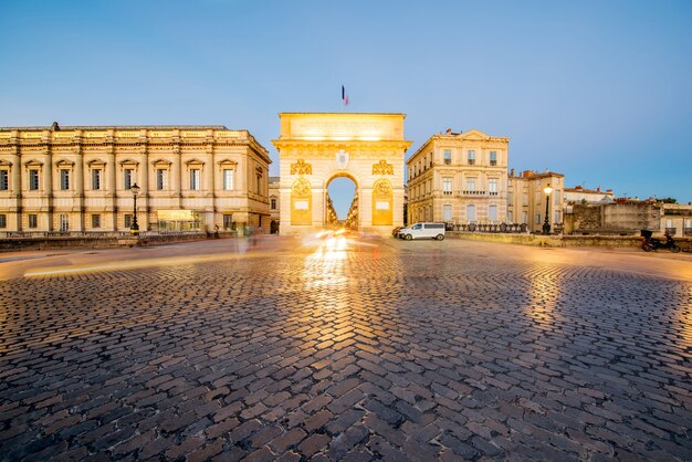 Straatmening op de verlichte triomfboog tijdens de avond in de stad Montpellier in de regio Occitanie in Frankrijk