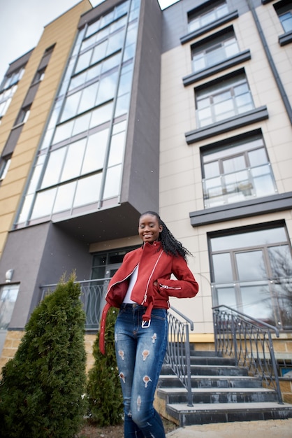 Foto straatmodeportret van een jonge, mooie afro-amerikaanse vrouw die door de stad loopt