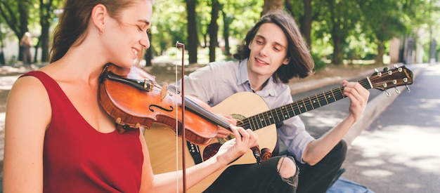 Straatmuzikant romantische date. duetten optreden. paar houdt ervan om samen instrumenten te spelen. kunst creatie inspiratie concept