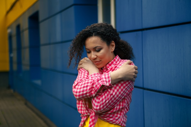 Straatportret van een jonge Afro-Amerikaanse vrouw die een grijze trui draagt