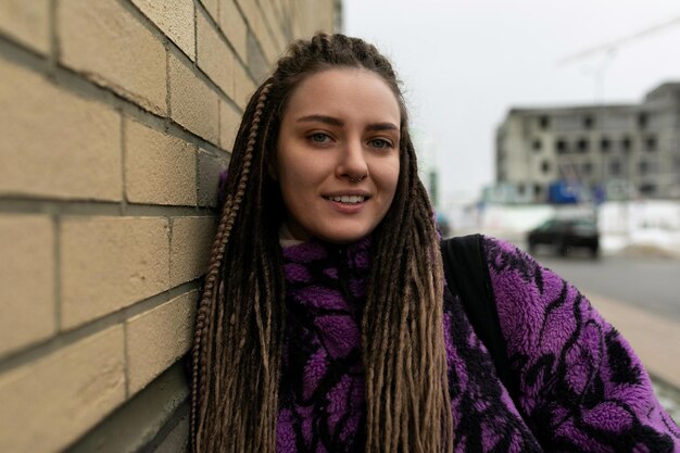 Straatportret van een jonge vrouw met dreadlocks