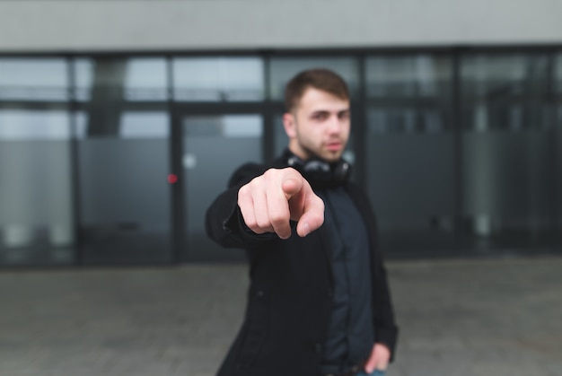 Foto straatportret van een man in een pak dat een vinger toont