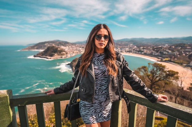 Straatstijl blanke brunette die vanaf de hoogte naar de stad San Sebastian kijkt