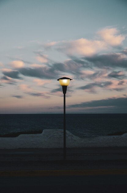 Foto straatverlichting door de zee tegen de hemel bij zonsondergang