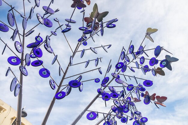 Straatversieringen in de vorm van een boom versierd met een groot aantal blauwe nazarstenen van het boze oog tegen de blauwe lucht