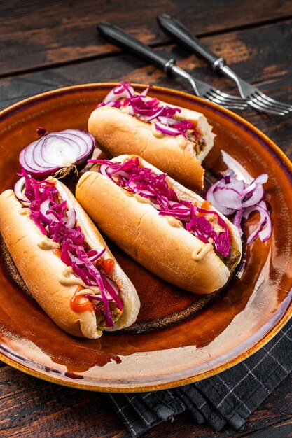 Straatvoedsel - Veganistische hotdogs met kool en vleesloze worst. Donkere houten achtergrond. Bovenaanzicht.