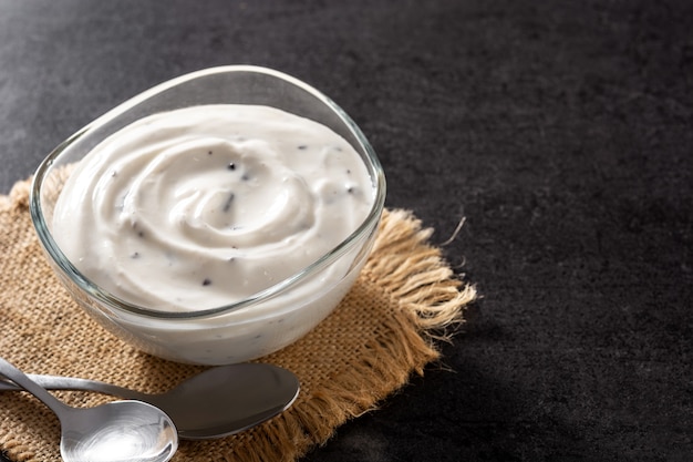 Stracciatella yogurt in transparent bowl on black background