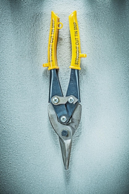 Straight cut tin snips on concrete surface construction concept