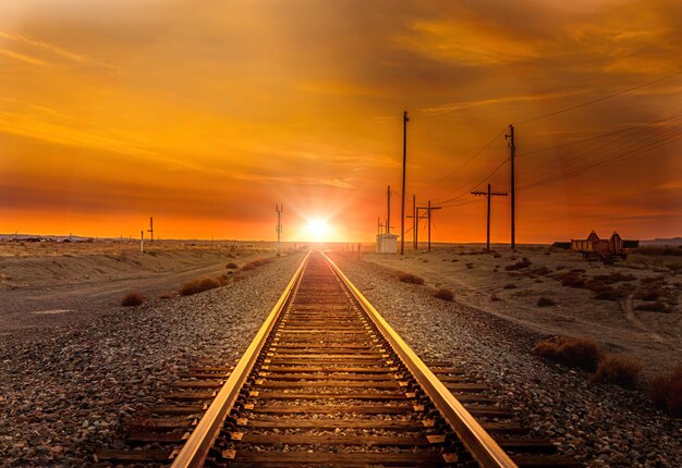 Straight railroad heading west towards the sunset somewhere in utah