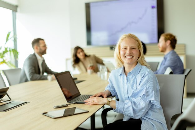 Foto stralende professionele vrouw die glimlacht tijdens een productieve bestuursvergadering op een zonnige middag