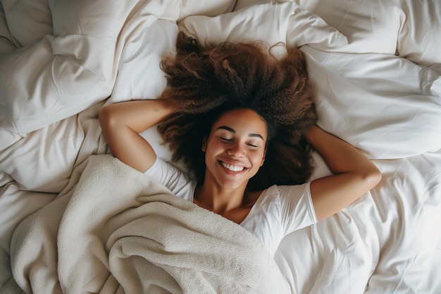 Foto stralende vrouw liggend in bed met handen achter het hoofd