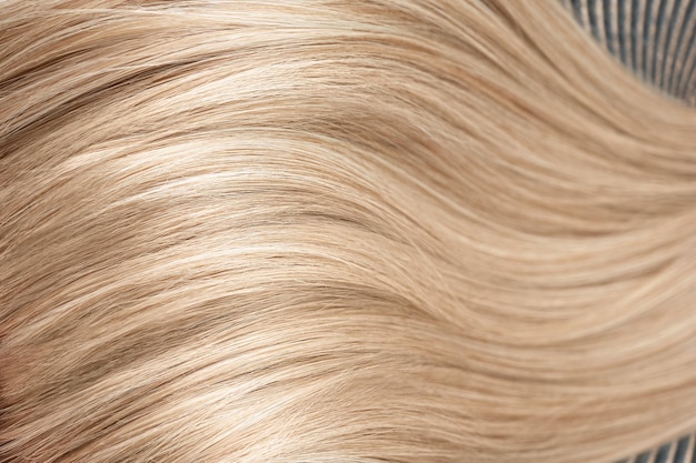 A strand of blond hair on a white background Closeup