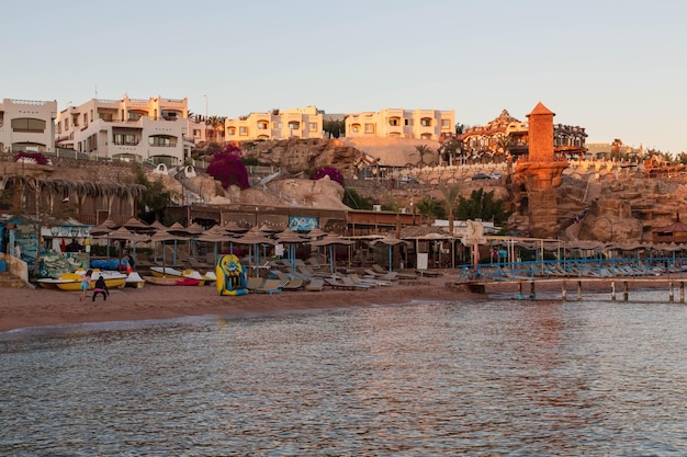 Strand en 's avonds een hotel op de rotsen bij Sharks Bay. Sharm El Sheikh, Zuid-Sinaï, Egypte
