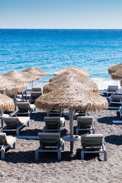 Strand met parasols en ligstoelen in Santorini