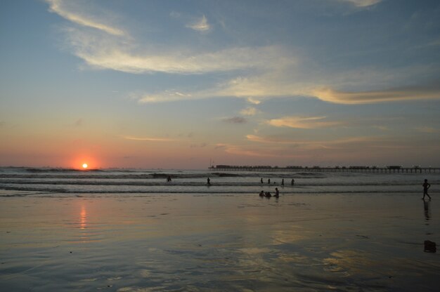 Strand met zee en pier en mensen