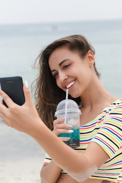 Strand vrouw koud drankje drinken met plezier op strandfeest drinken