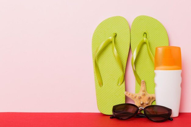 Strandaccessoires Slippers en zeesterren op gekleurde achtergrond Mock up met kopieerruimte