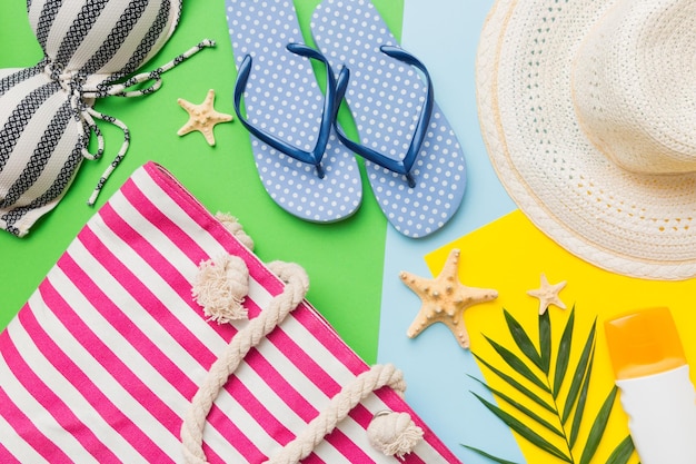 Strandaccessoires strohoed en zeeschelp op gekleurde tafel Zomer concept achtergrond