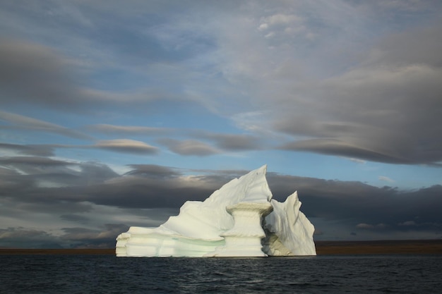 Nunavut의 Pond Inlet 근처 북극 풍경에서 저녁 무렵 좌초된 표 모양의 빙산과 얼음