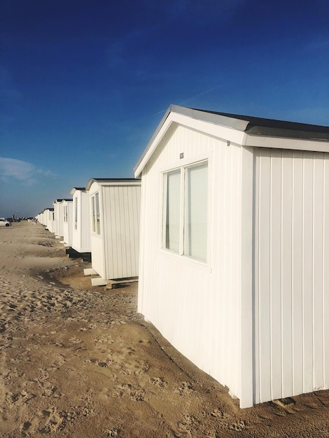 Strandhutten bij gebouwen tegen een blauwe lucht