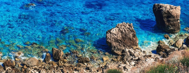 Strandlandschap van het eiland Lefkada Griekenland bovenaanzicht van zeeblauwe golven, zonnige rotsen en kliffen