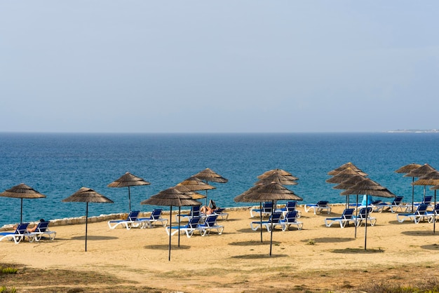 Strandligbedden en parasols met uitzicht op turquoise water