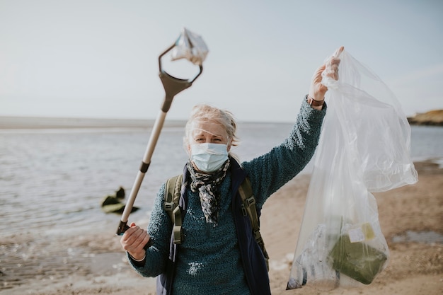 Strandopruimingsvrijwilliger met vuilniszak voor milieucampagne