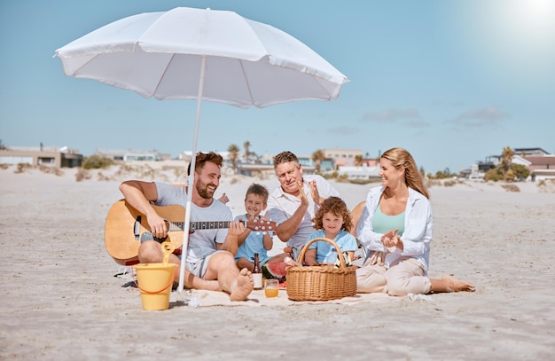 Strandpicknick of gelukkige familie houden van gitaarmuziek terwijl ze een band opbouwen of ontspannen tijdens de zomervakantie Grootvader vader en moeder genieten van quality time met kinderen broers en zussen die watermeloenfruit eten