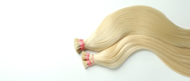 Strands of blond hair on white background