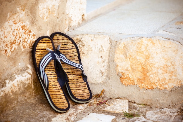 Strandslippers op de oude muurachtergrond Horizontaal schot