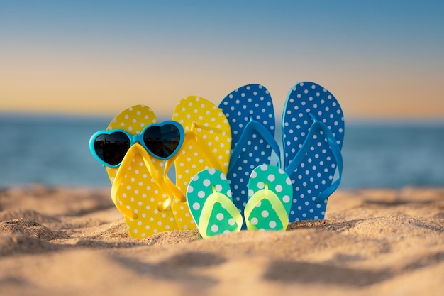 Strandslippers op het zand tegen zee en hemelachtergrond Zomervakantieconcept