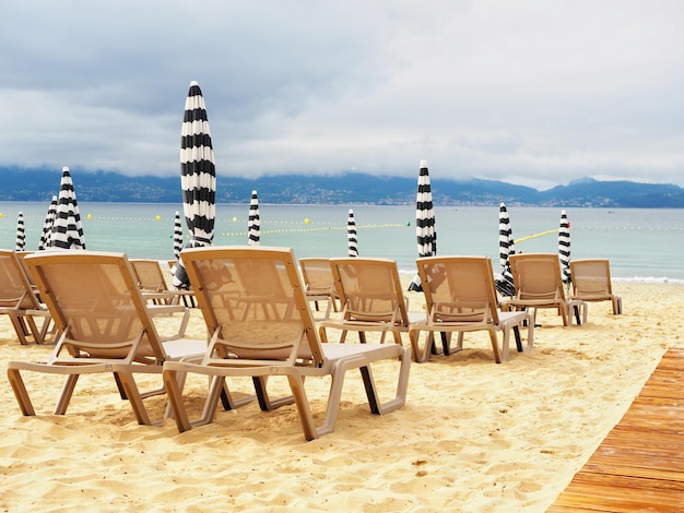 Strandstoelen met gesloten parasols op een bewolkte dag