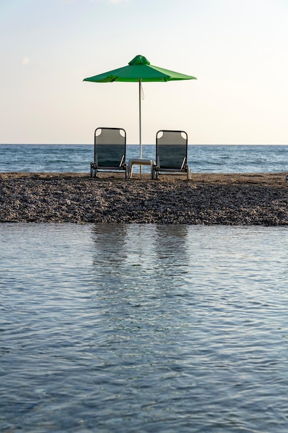 Foto strandstoelen onder parasols op een zandig schiereiland tussen zee en rivier bij georgioupoli, kreta