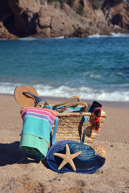 Strandtas met een boek en een telefoon en een zonnebril vergezeld door een zeester