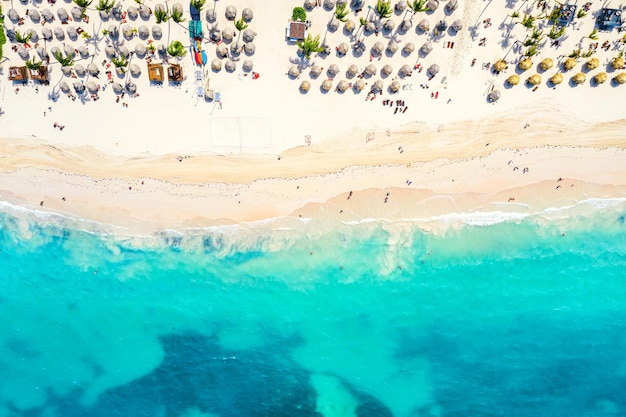 Strandvakantie en reizen achtergrond. Luchtfoto drone uitzicht op prachtige Atlantische tropische strand met stro parasols en palmen. Bavarostrand, Punta Cana, Dominicaanse Republiek.