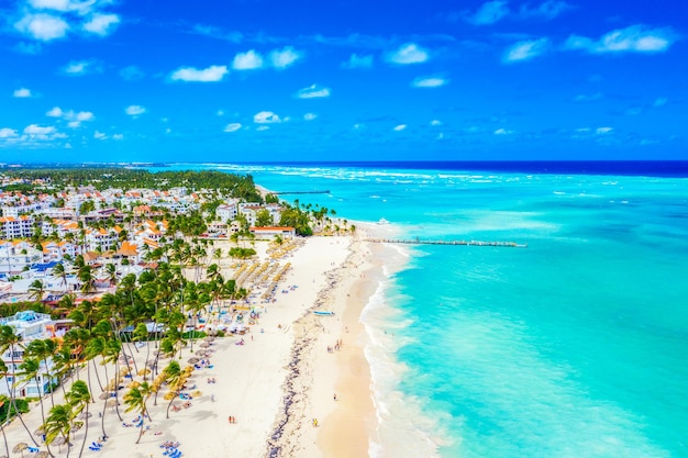 Strandvakantie en reizen achtergrond. Luchtfoto drone uitzicht op prachtige Atlantische tropische strand met stro parasols, palmen en boten. Bavarostrand, Punta Cana, Dominicaanse Republiek.
