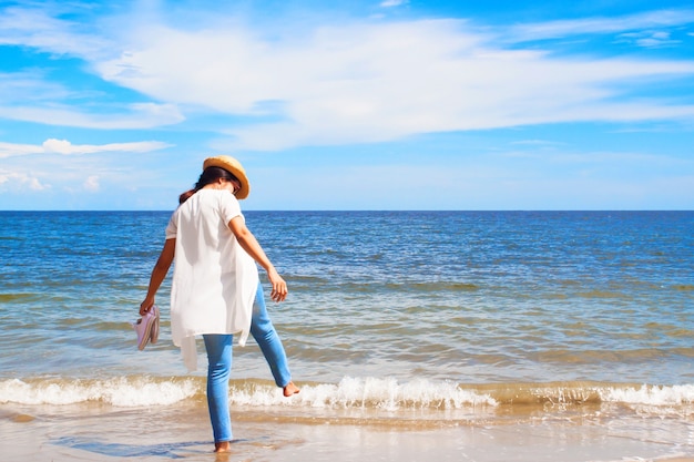 Strandvakantie, Gelukkige mooie vrouw die in jeans van zonnige dag op strand, Vrijheidsvrouw, Levensstijlconcept genieten