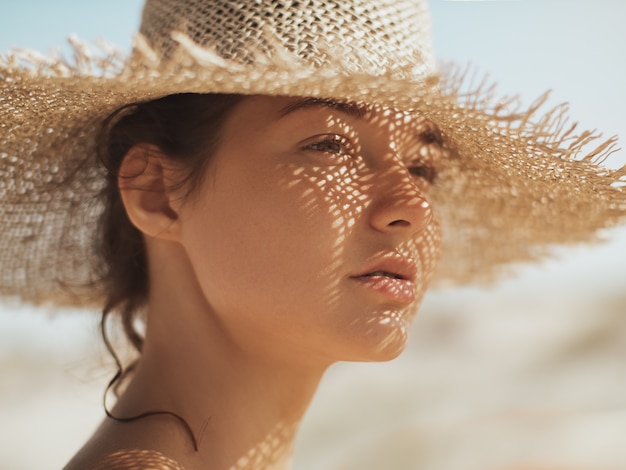 Strandvrouw in zonnehoed op vakantie