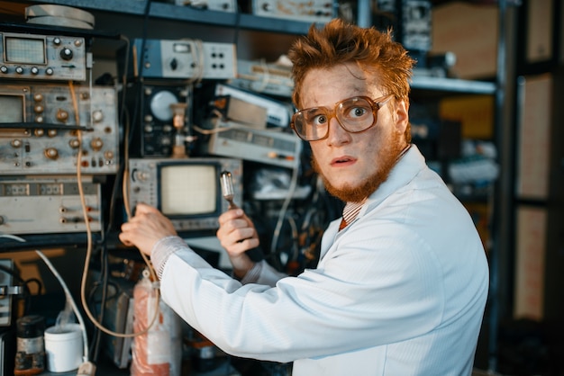 Strange engineer holds electric tube in laboratory