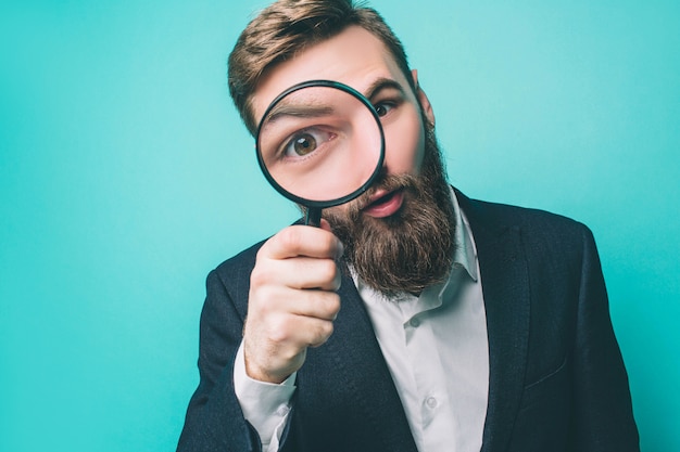 Strano uomo guarda dritto attraverso la lente d'ingrandimento