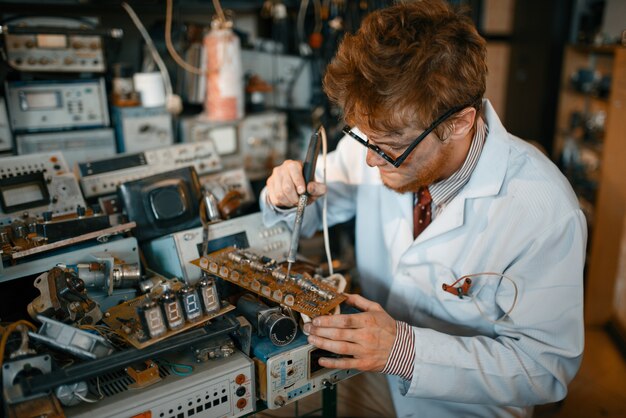 Photo strange scientist soldering chips, test in laboratory. lab equipment, engineering workshop