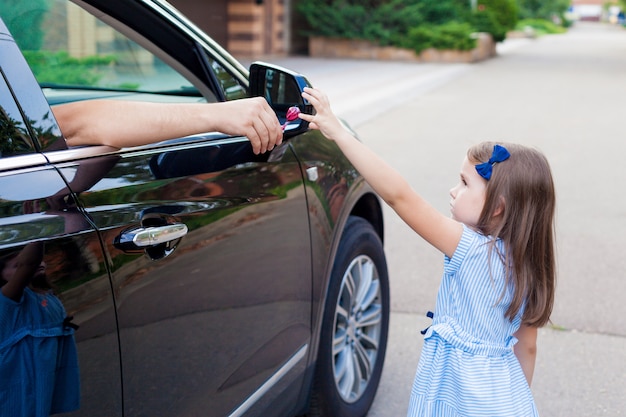 車の中で見知らぬ人が子供にキャンディを提供しています