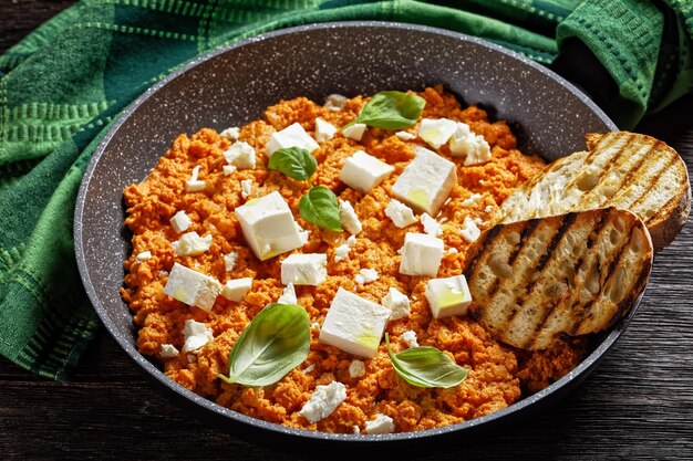 Strapatsada-eieren roerei met tomaten en feta-kaas in een koekenpan met geroosterd brood horizontale weergave Griekse keuken