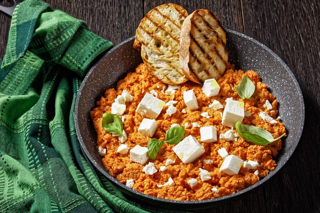 Strapatsada-eieren roerei met tomaten en feta-kaas in een koekenpan met geroosterd brood horizontale weergave Griekse keuken