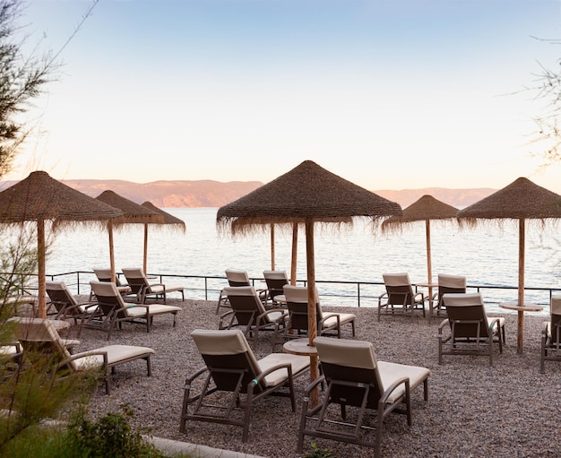 Photo straw beach umbrellas on the beach of rabac croatia