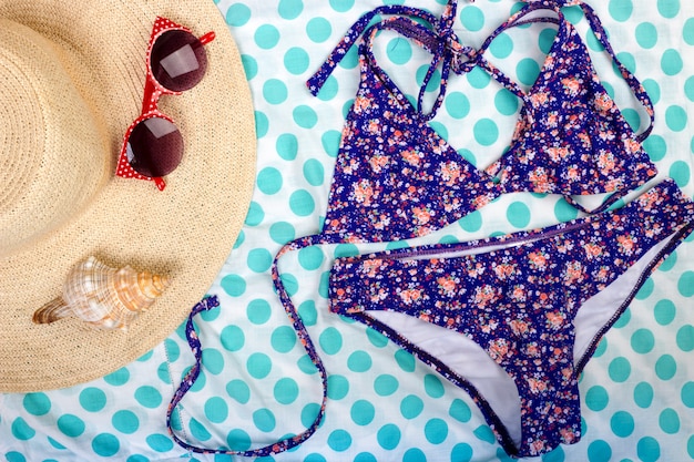 Foto straw beach cappello da donna occhiali da sole vista dall'alto seashell costume da bagno donna con spazio per il testo.