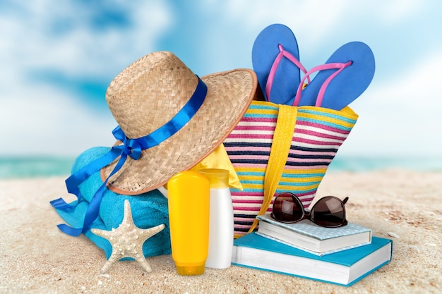 Straw hat, bag,  flip flops on a tropical beach