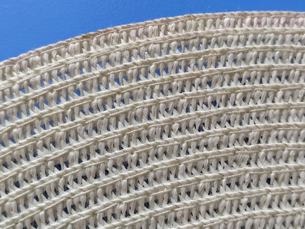 Straw hat on a blue background The edge of the wide brim of the hat Weave threads or twigs