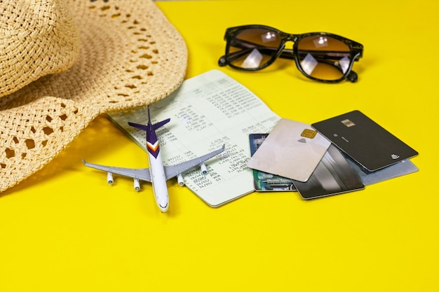 Straw hat credit cards airplane sun glasses account book budgeting and expensed in traveling plan or trip vacation time financial concept