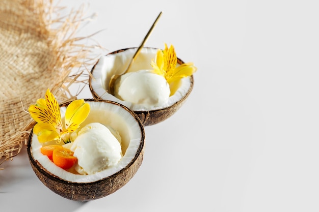 Straw hat and ice cream in half of coconut. Summer Vacation concept.